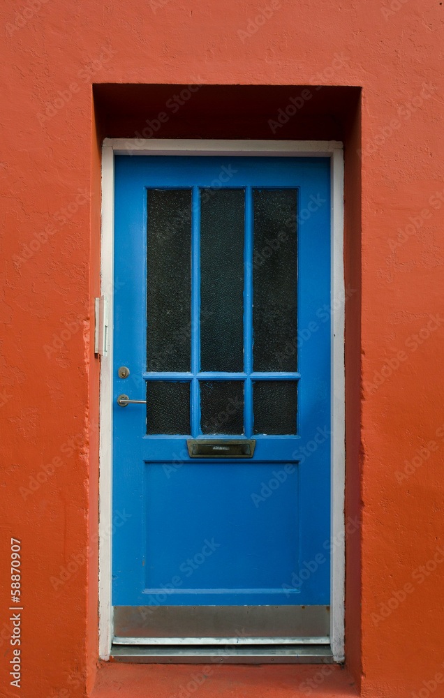 Naklejka premium Blue wooden door on a red wall, Reykjavik, Iceland
