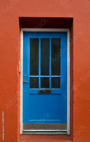Blue wooden door on a red wall, Reykjavik, Iceland