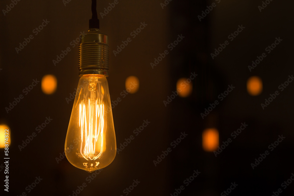 Glowing lightbulb dangling from the ceiling Glowing lightbulb dangling from the ceiling