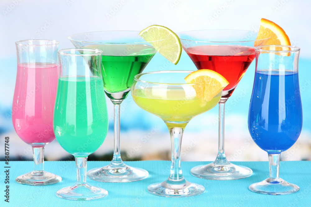 Glasses of cocktails on table near pool Glasses of cocktails on table near pool
