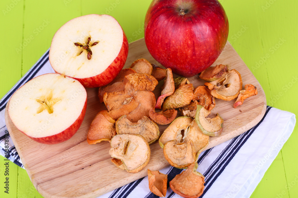 Dried apples, on cutting board, on color wooden background Dried apples, on cutting board, on color wooden background