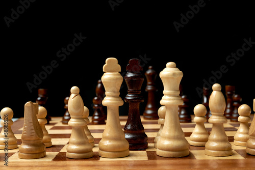 wooden chess board with chess pieces on.