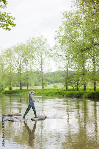 woman fishing in Sazava river, Czech Republic