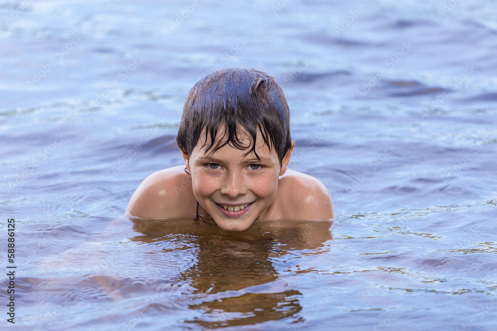 Little boy swimming in a lake