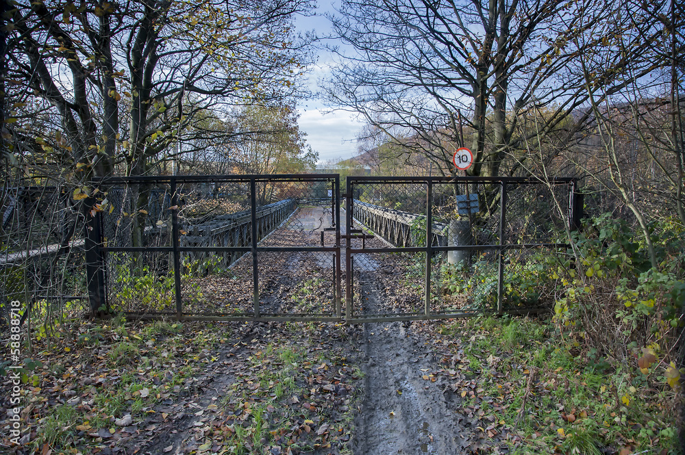 gated and locked fence across roadbridge