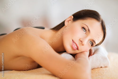 beautiful woman in spa salon with hot stones