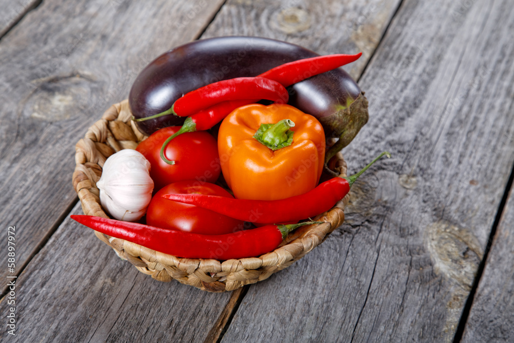 Wattled basket with vegetables on an old table Wattled basket with vegetables on an old table