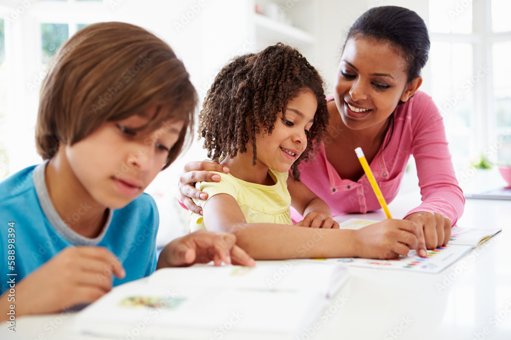 Mother Helping Children With Homework In Kitchen Mother Helping Children With Homework In Kitchen