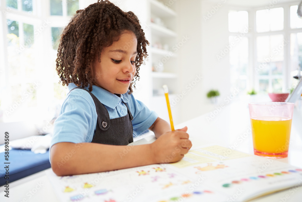 Girl In School Uniform Doing Homework In Kitchen Girl In School Uniform Doing Homework In Kitchen