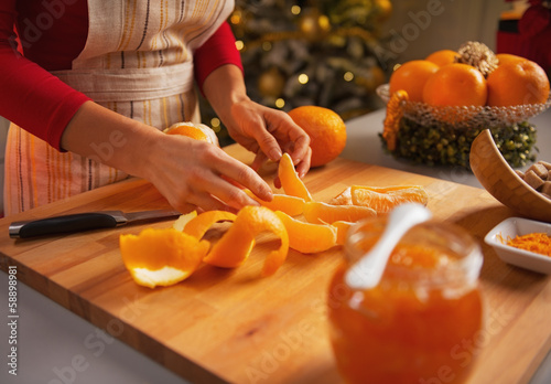 Closeup on young housewife making orange jam photo