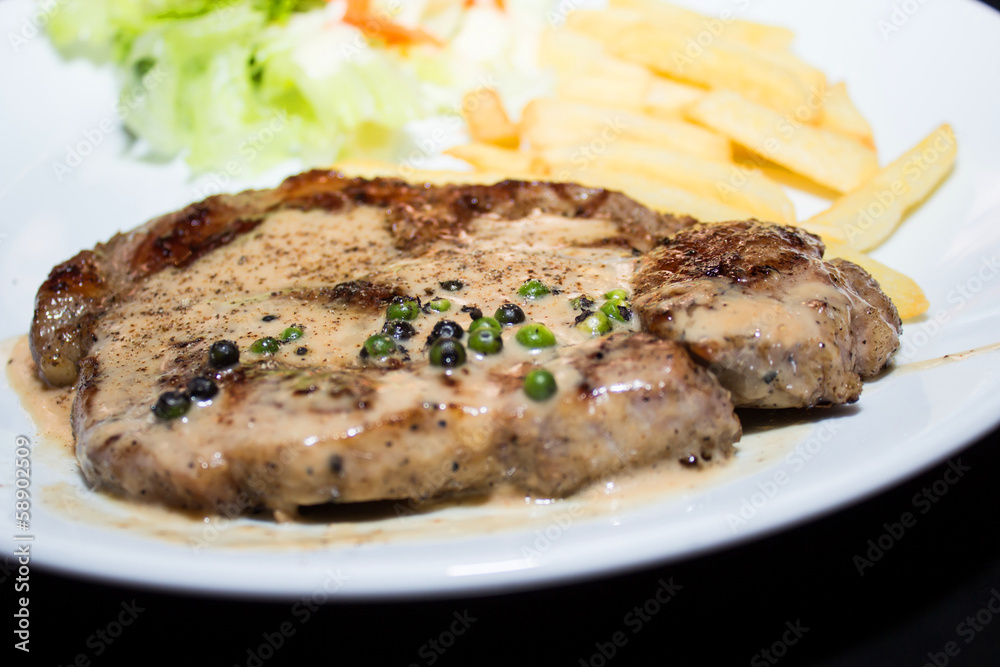Beef steak with black pepper sauce on a white plate Beef steak with black pepper sauce on a white plate