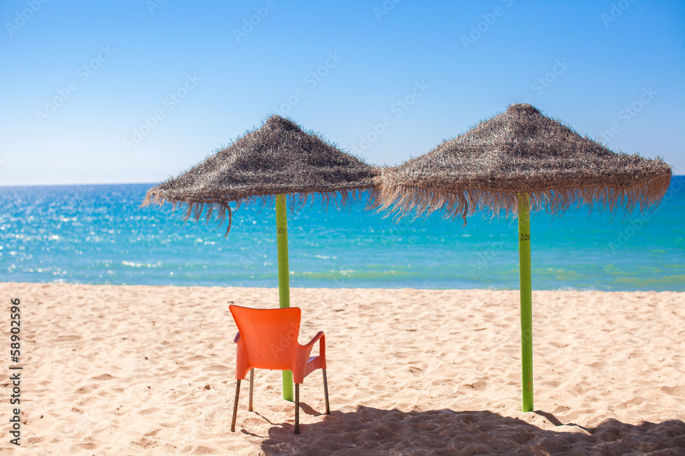 Straw umbrellas on empty tropical beach on the Atlantic coast