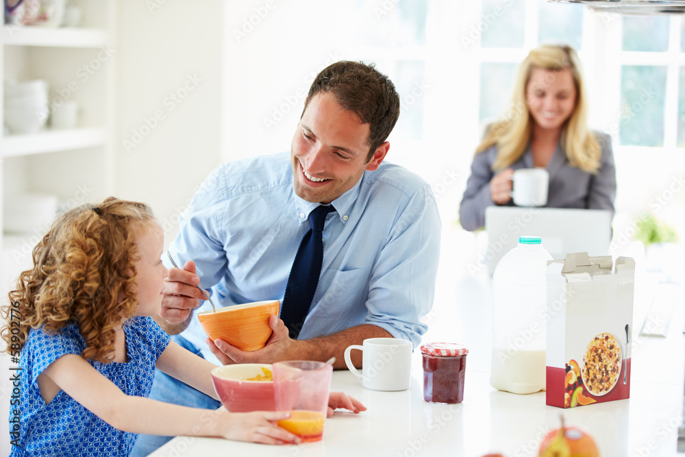 Parents And Daughter Having Breakfast In Kitchen Together