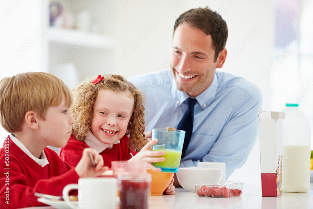 Father And Children Having Breakfast In Kitchen Together