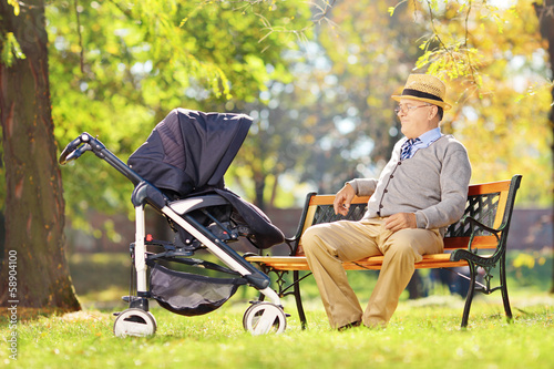 Fotografie Grandfather sitting on a bench and looking at his nephew