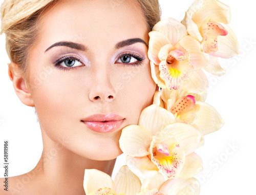woman with healthy skin and flowers close to face