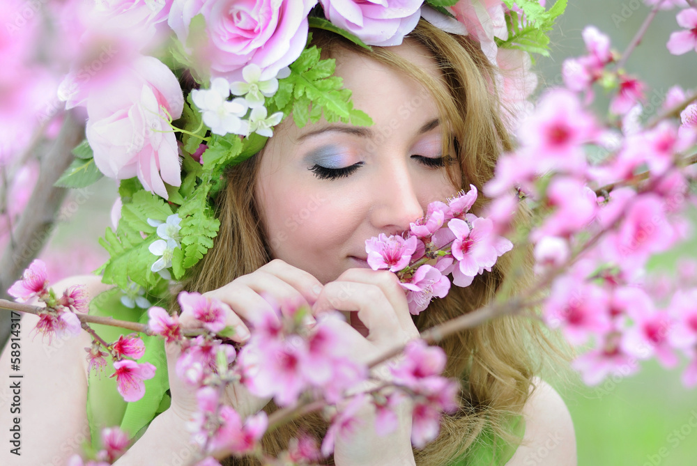 Beautiful girl in a flowered garden peach