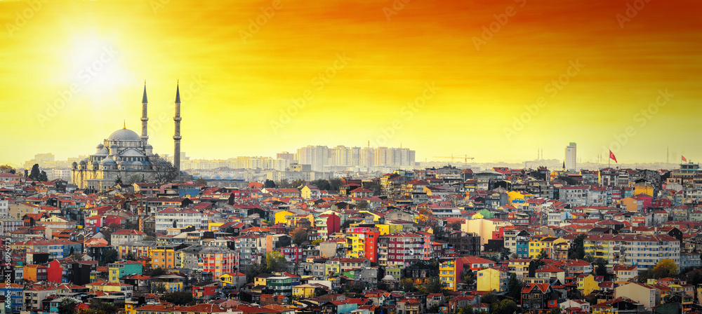 Naklejka premium Meczet w Stambule z kolorową dzielnicą mieszkalną o zachodzie słońca