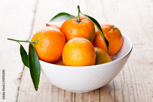 tangerines with leaves in bowl