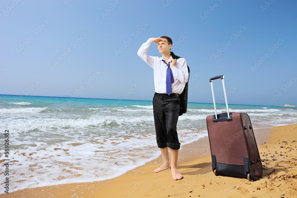 Lost businessman with his luggage searching for way on a beach Lost businessman with his luggage searching for way on a beach