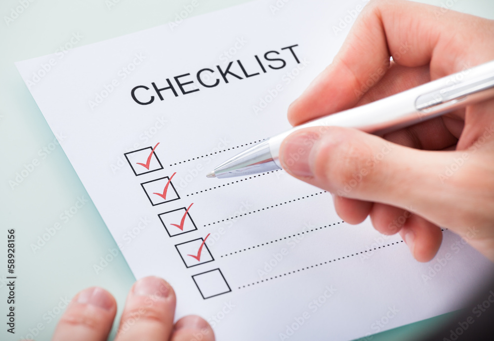 Person's Hand Marking On Checklist With Pen Person's Hand Marking On Checklist With Pen