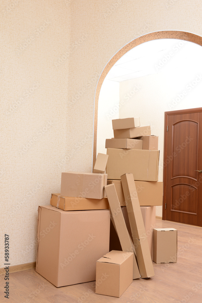 Fototapeta premium Empty room with stack of cartons: moving house concept