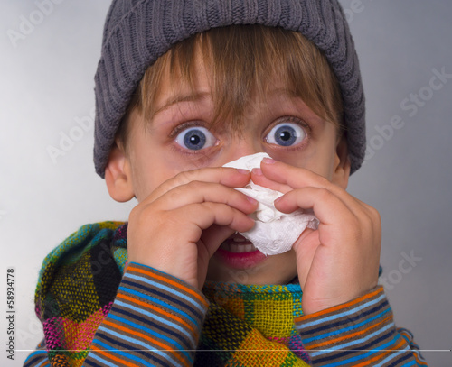 Foto Beautiful boy wipes nose with napkin