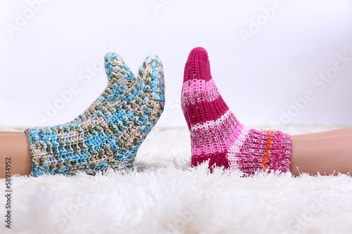 Legs in colorful socks on white carpet background