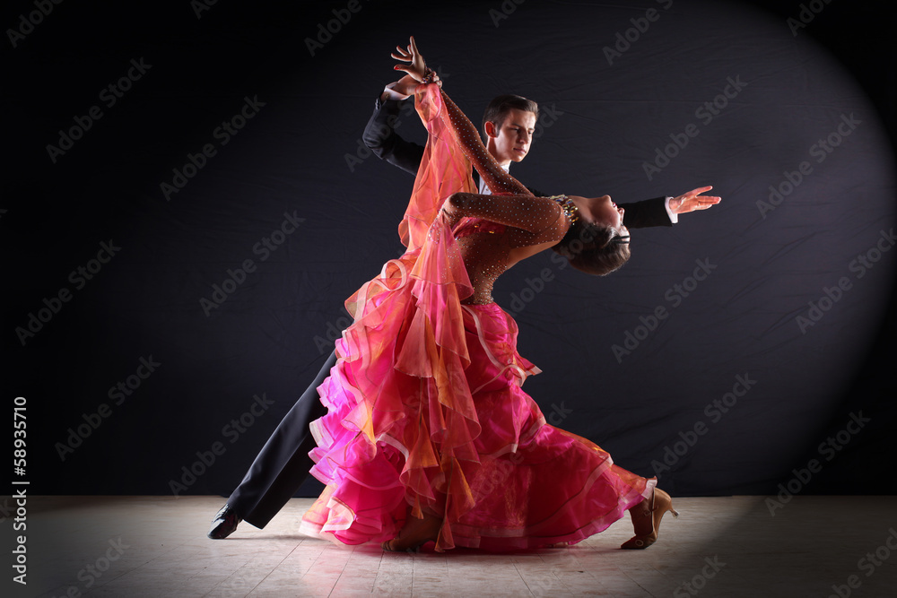 Latino dancers in ballroom against black background Latino dancers in ballroom against black background