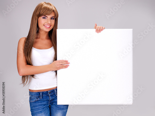 Young smiling woman holds white big banner