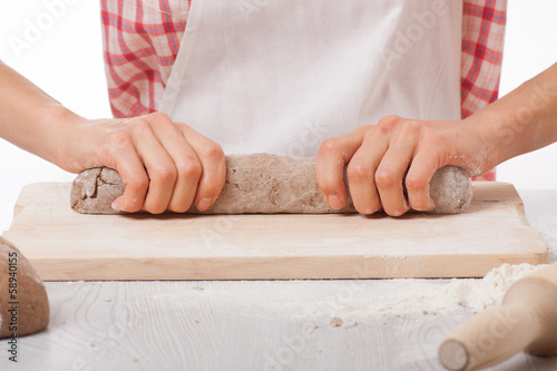 hands knead rye dough