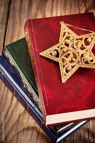 books with christmas star on wooden background