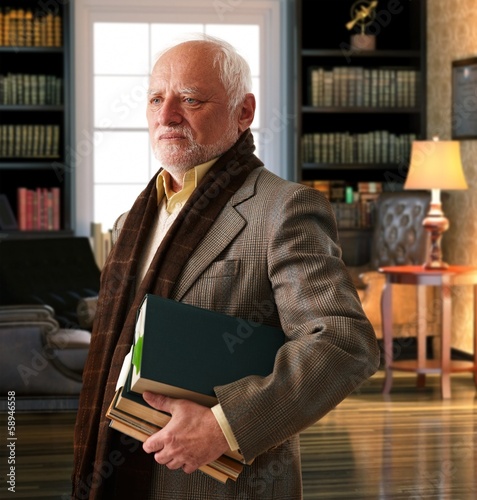 Elderly professor with books at library room photo