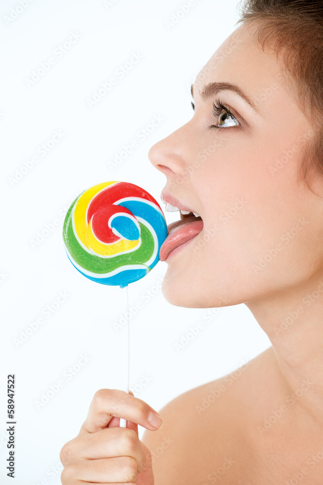 Beautiful young girl with a lollipop near her lips