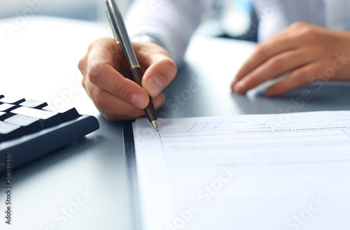 Businesswoman sitting at office desk signing a contract