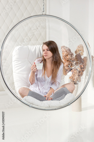 Girl sitting in a chair suspended round