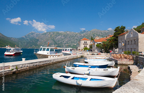 White fishing boats float moored in Perast. Kotor Bay