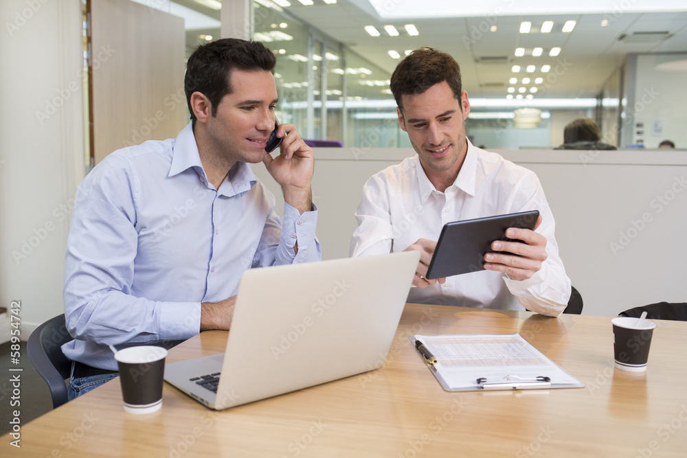 Two casual businessmen working together in modern office