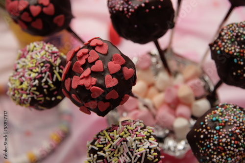 Cake pops au chocolat décorés de vermicelles colorés sur fond rose