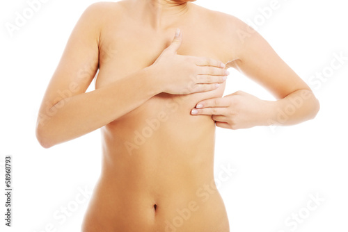 Young topless woman is examinning her breasts.