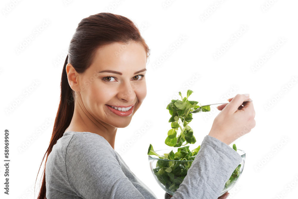 Young casual woman eating lamb's lettuce.