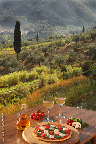 Italian pizza and glasses of white wine in Chianti, Italy photo