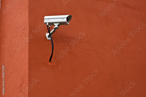 CCTV security camera and red wall.