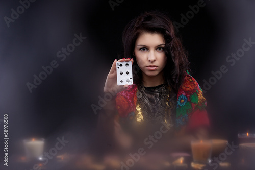 Attractive young fortune teller holdin card
