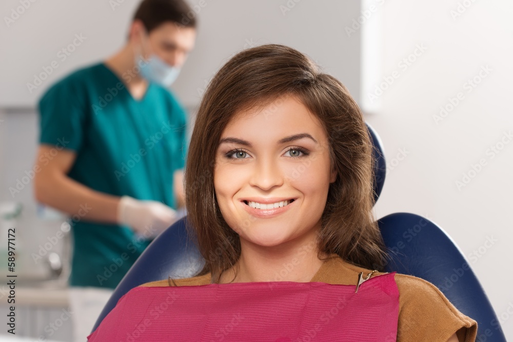 Man dentist reading woman patient's card Man dentist reading woman patient's card