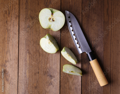 Kitchen knife and green apple,   on wooden background photo