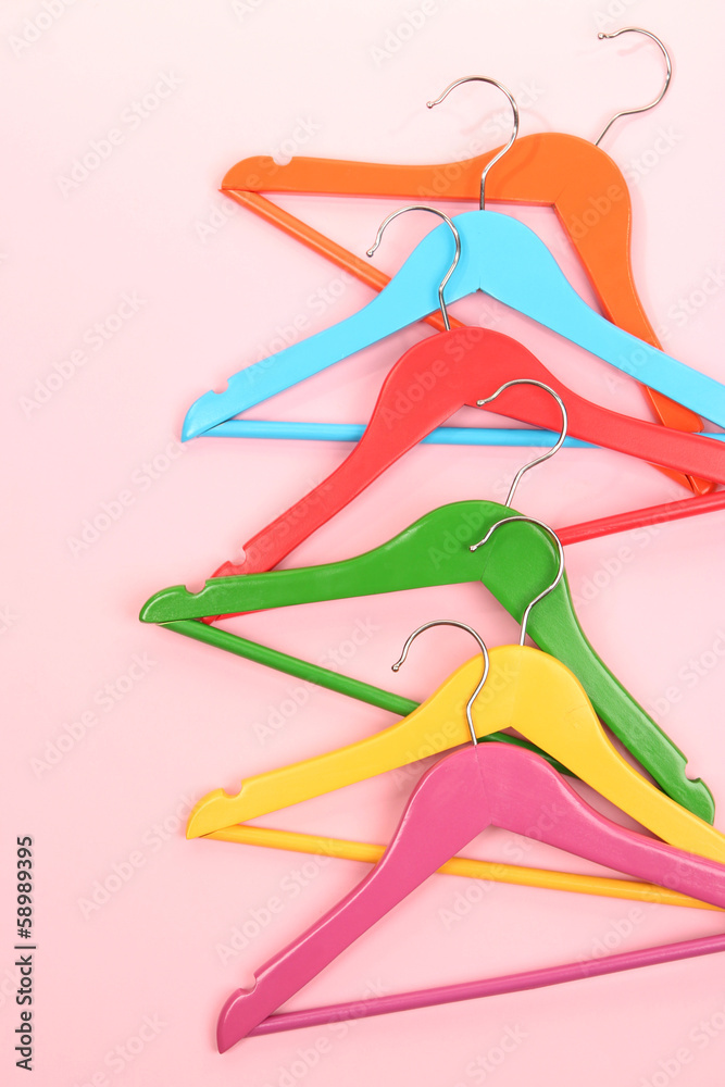 Colorful clothes hangers on pink background Colorful clothes hangers on pink background