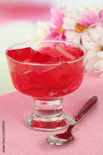 Tasty jelly cubes in bowl on table on light background