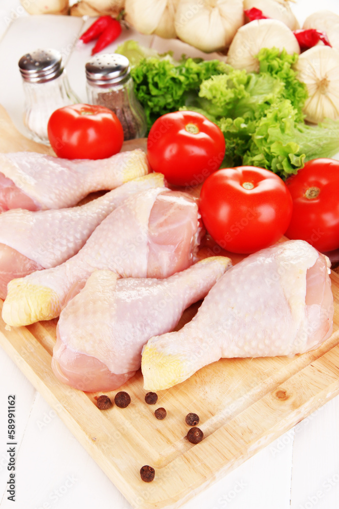 Raw chicken legs on wooden board close up Raw chicken legs on wooden board close up