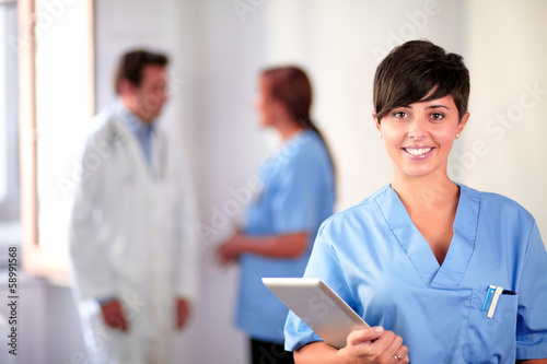 Obraz na plátně Lovely latin nurse on blue uniform standing